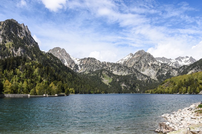 a choppy mountain lake under patchy clouds, peaceful mountain lake 4k