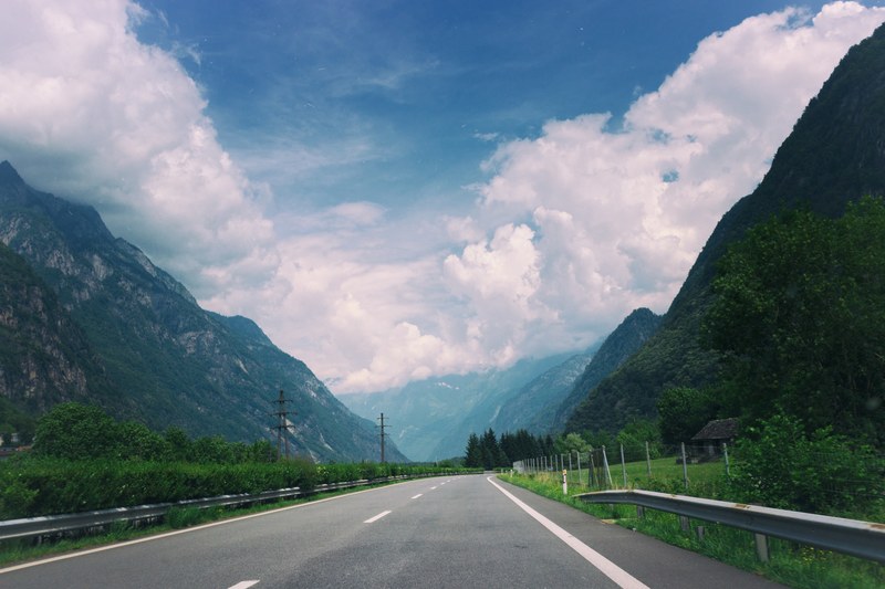 an empty road in a rural mountain valley on a cloudy day, road through a mountain village 4k