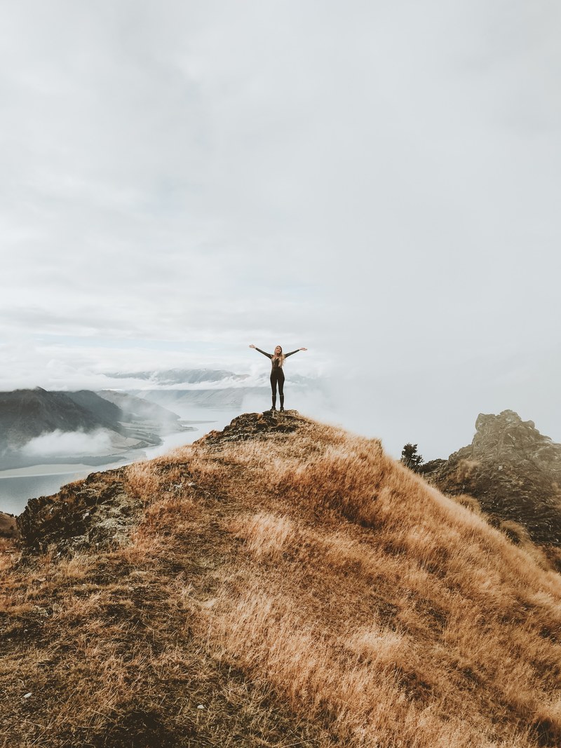 a woman standing on a cliff with her arms spread open, _standing edge cliff 4k