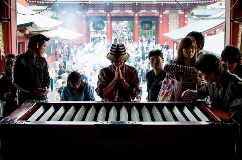 diverse group of tourists visit and pray at a landmark asian temple, temple sightseeing 4k
