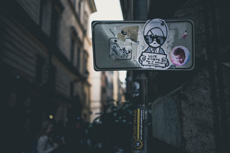 graffiti and stickers on a street sign in alley of an urban area, graffiti sticker sign 4k
