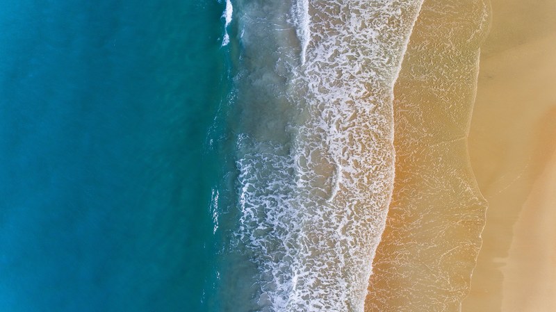 drone aerial view of the ocean washing on the sand beach shore at palm coast florida united states, ocean waves drone view 4k