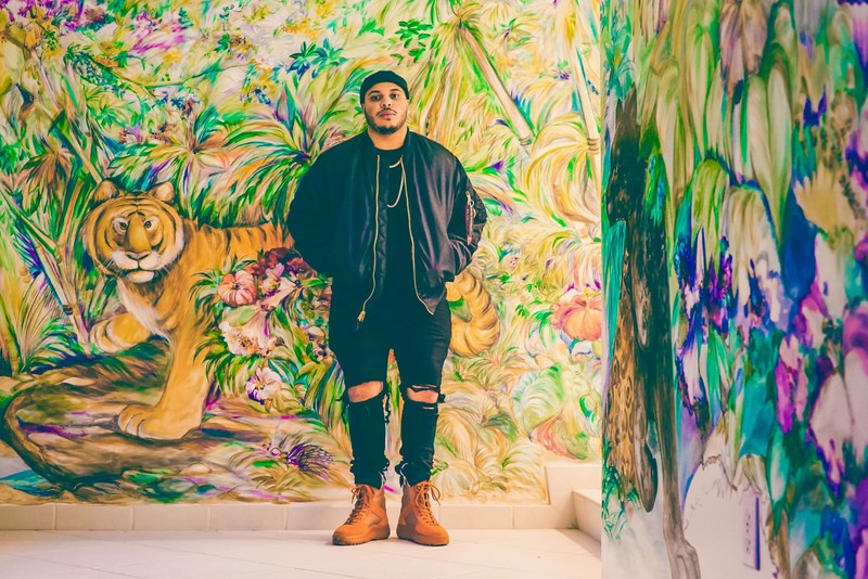 man standing in front on a colorful mural of a tiger and jungle flowers, the jungle 4k