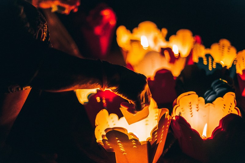 person places candles inside paper takeout container lanterns, glowing paper lanterns 4k