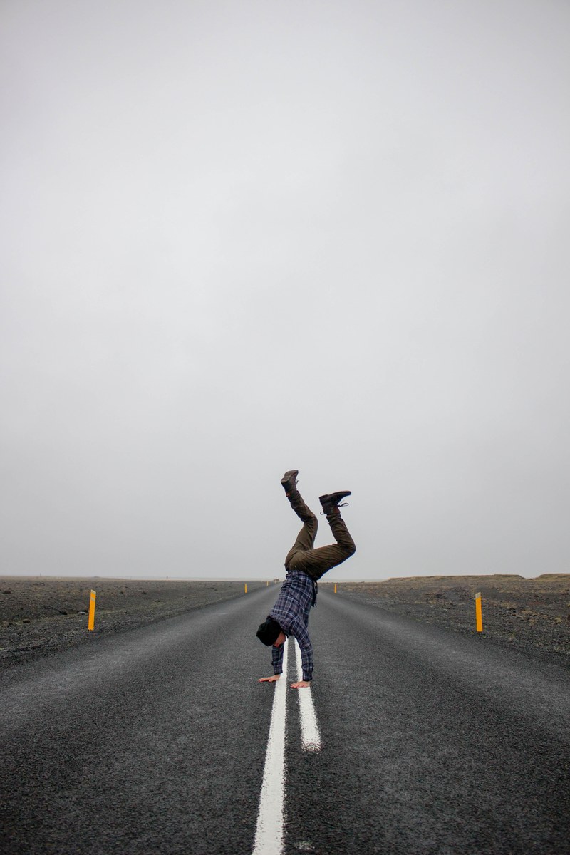 a person doing a handstand in the middle of the road, _handstand on road 4k