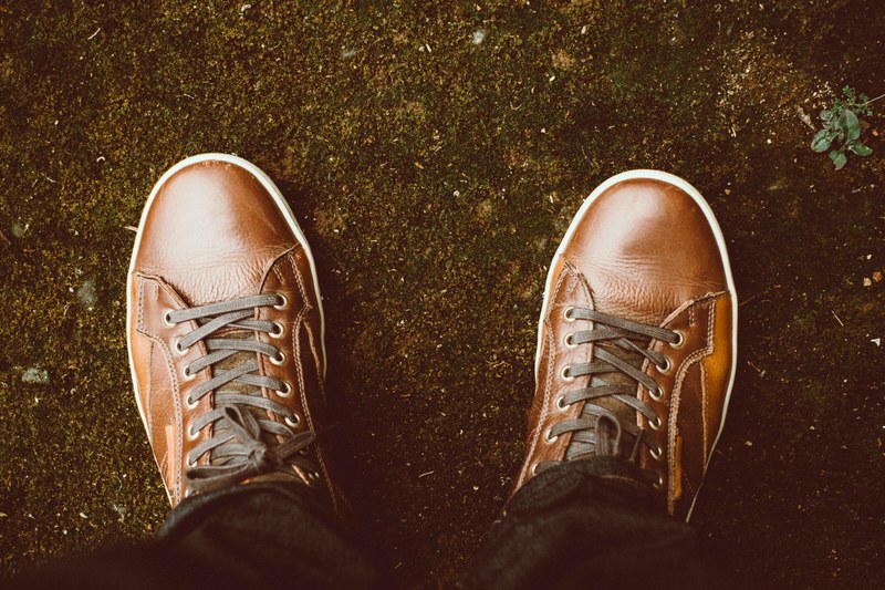 view from a man looking down at his brown shoes with laces, man looking down at shoes 4k