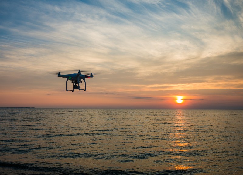 a drone flying over the sea capturing a cloudy orange sunset, sunset drone sky and water 4k