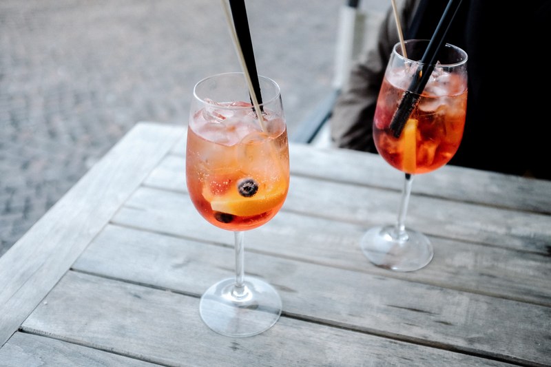 cold cocktail alcoholic wine drinks in glass with straw on a table in anzio, fruity cocktails 4k