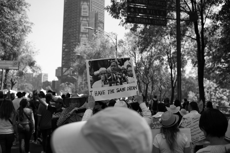 a crowd at a protest in mexico city and a sign picturing martin luther king jr, we all have the same dream_ 4k