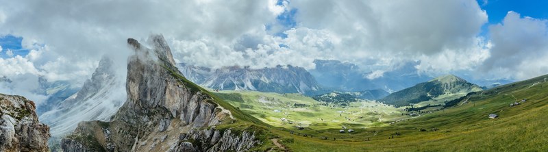 a beautiful mountainous landscape with white fluffy clouds over green fields and tall peaks in seceda, seceda 2_518 panorama 4k