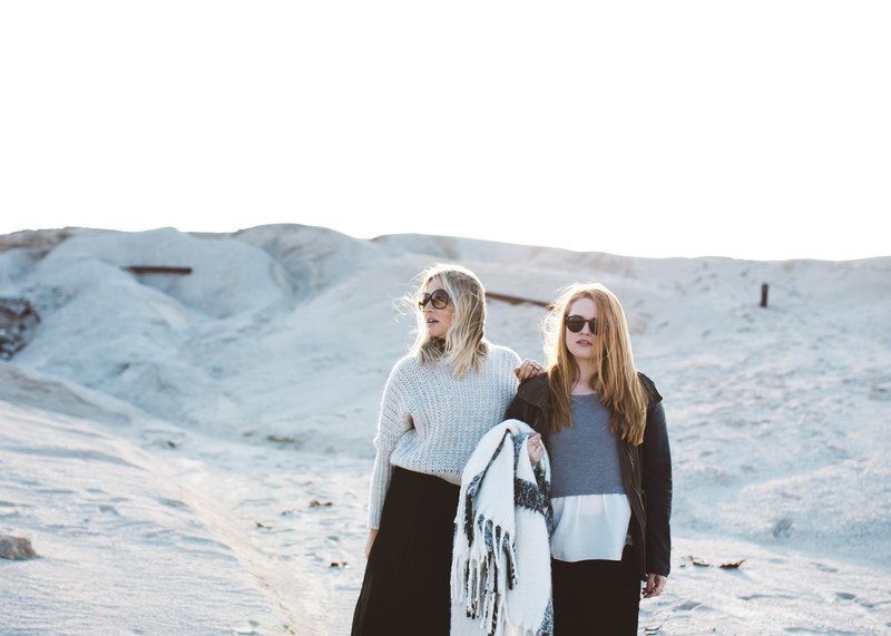 a blonde woman with her redhead daughter both wearing sunglasses whilst stood on the sand dunes of joplin, mom and daughter on the sand dunes 4k