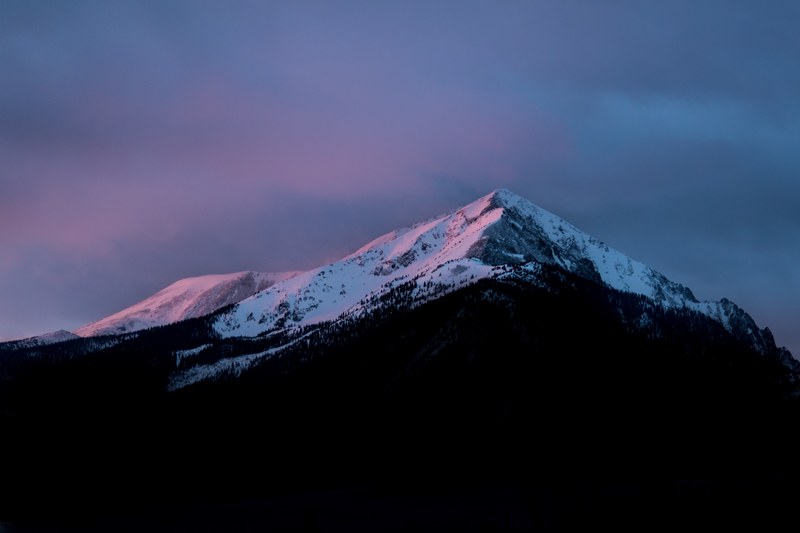 a sharp snow capped mountain peak in silverthorne during dusk, night falls on a silverthorne mountain 4k