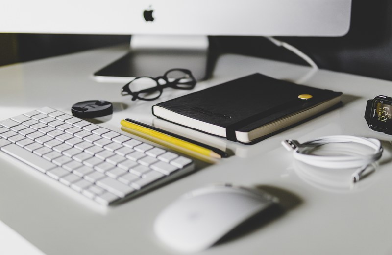 a busy desk with a keyboard a notebook a cable pencils and glasses near an imac, workspace 4k