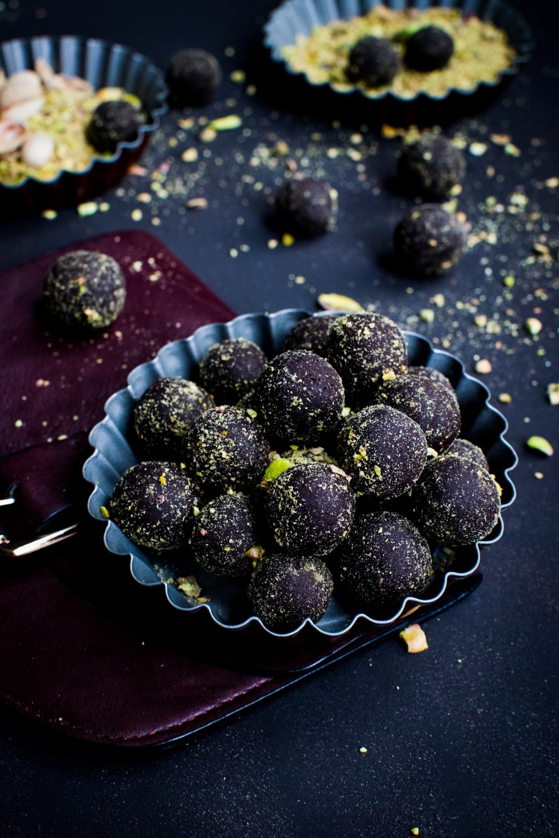 rustic bowls of dark chocolate truffle dessert rolled in pistachios, dark chocolate pralines with pistachios 4k