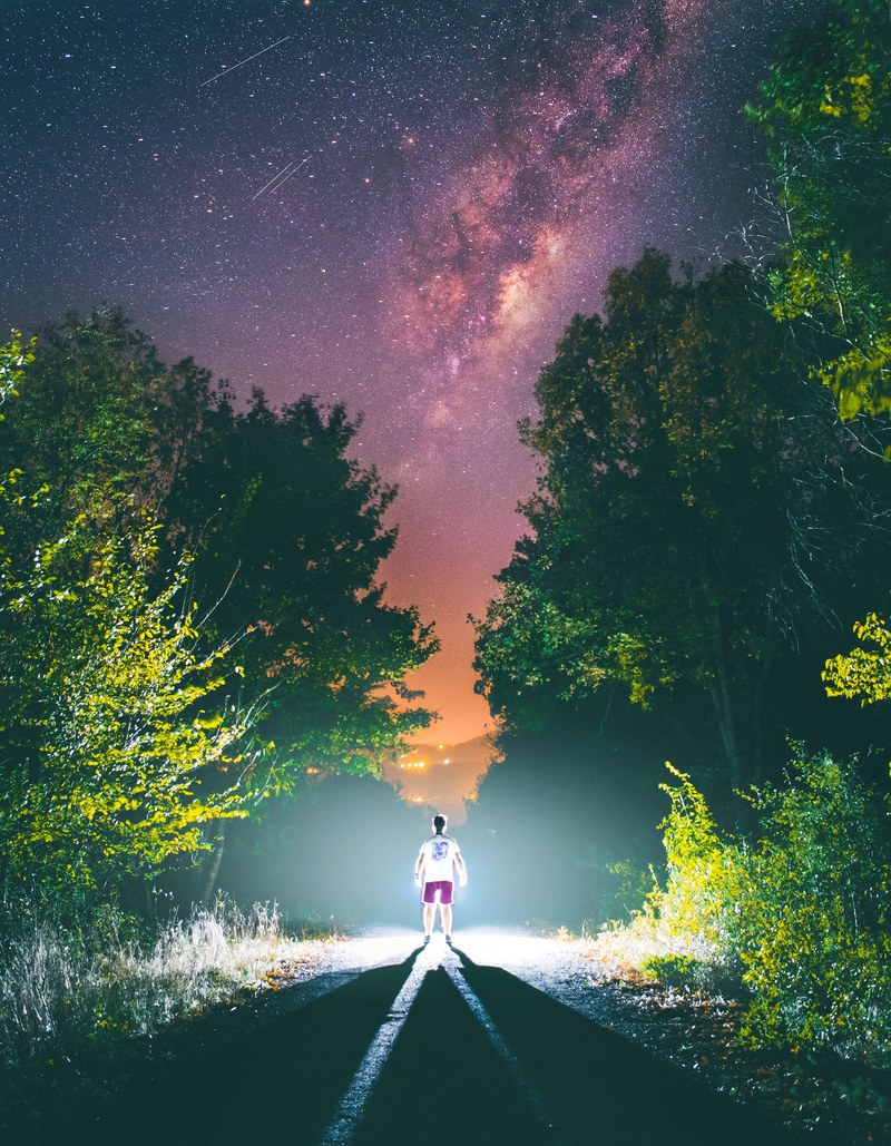 a woman walking down the middle of a road seen in a persons headlights, _person headlight walking 4k