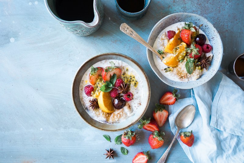 flat lay of healthy breakfast with bowls of fruit and oatmeal, breakfast by the window 4k