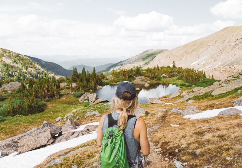 woman looking out at a mountain landscape on a scenic hike, solo mountain hike 4k