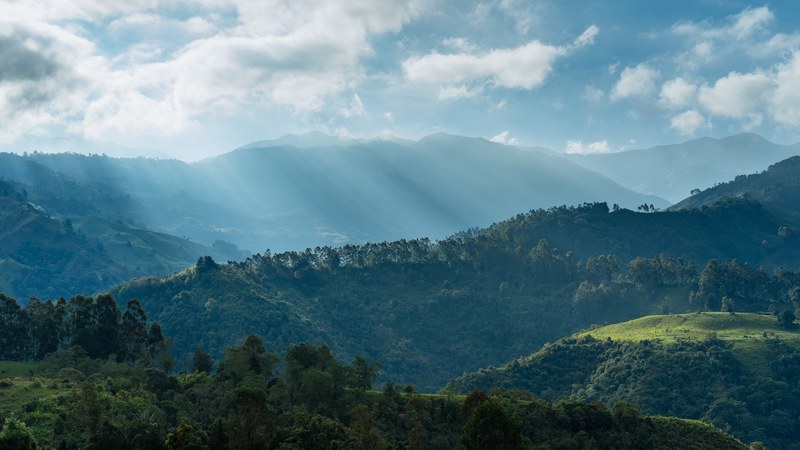 cloudy sky above tall wooded hills, morning over green hills 4k