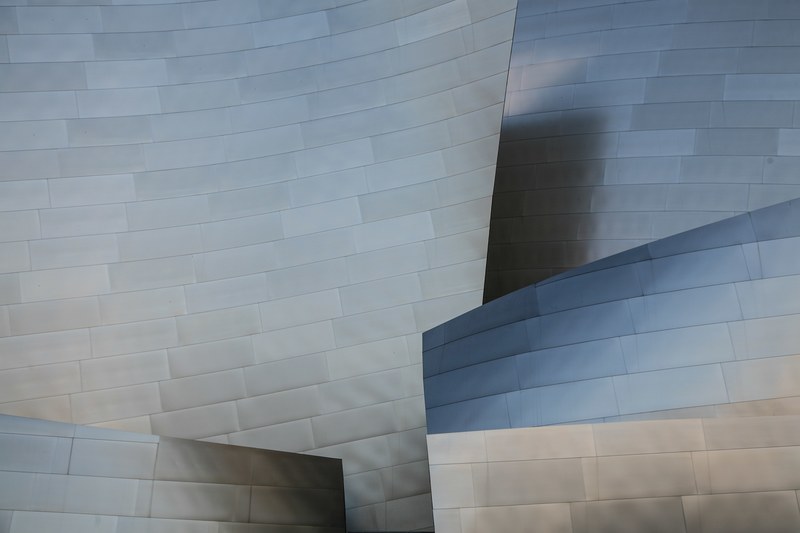 glossy steel panels in the modern facade of walt disney concert hall in los angeles, stainless curves 4k