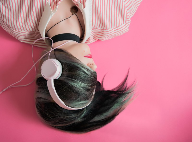 a dark haired woman with her hair wrapped around her hair listening to music on headphones, pink music 4k