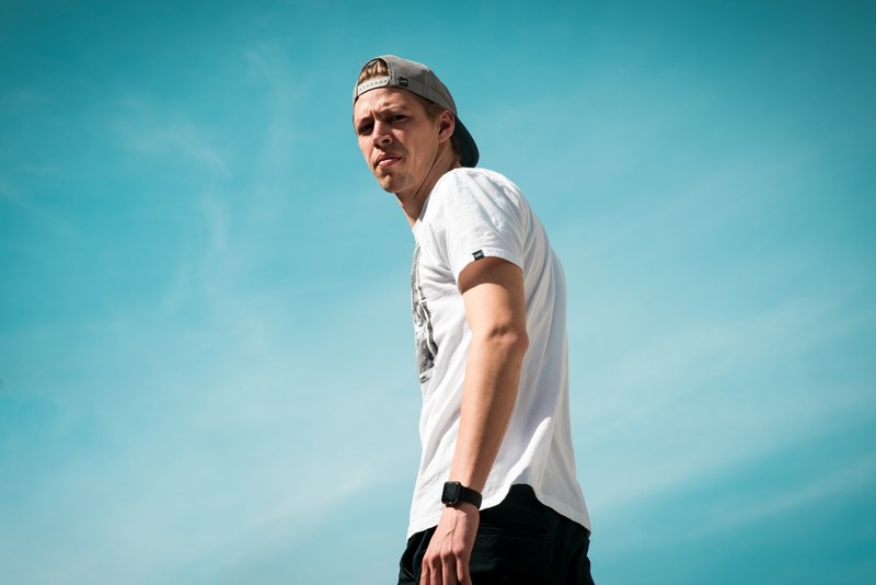 man looking down disgusted against a blue sky, grossed out 4k