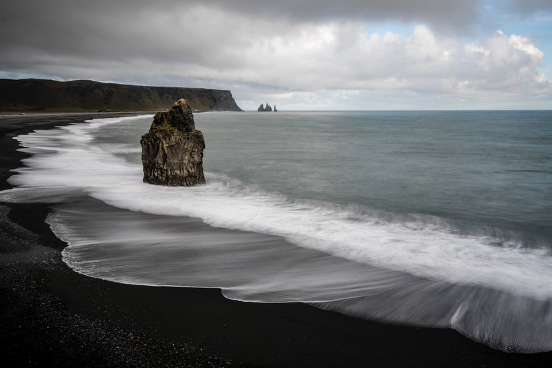 large rock on the black sand beach in vik, black beach at vik iceland 4k