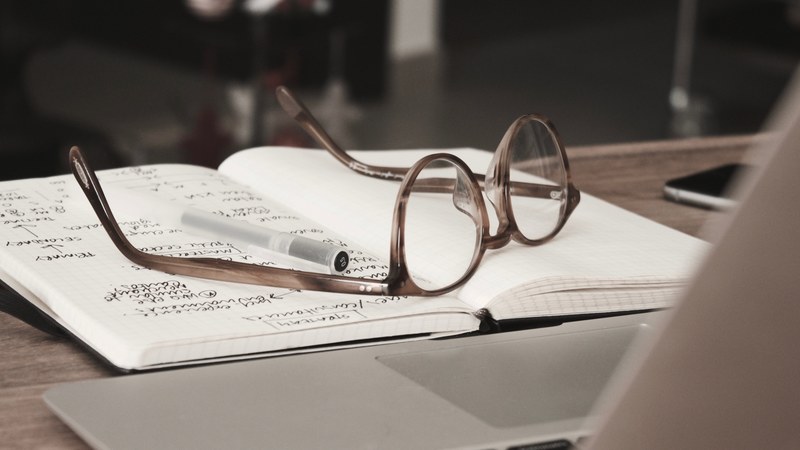 an imac computer glasses and notebook filled with notes sitting on a desk in dubai, glasses notebook and laptop 4k