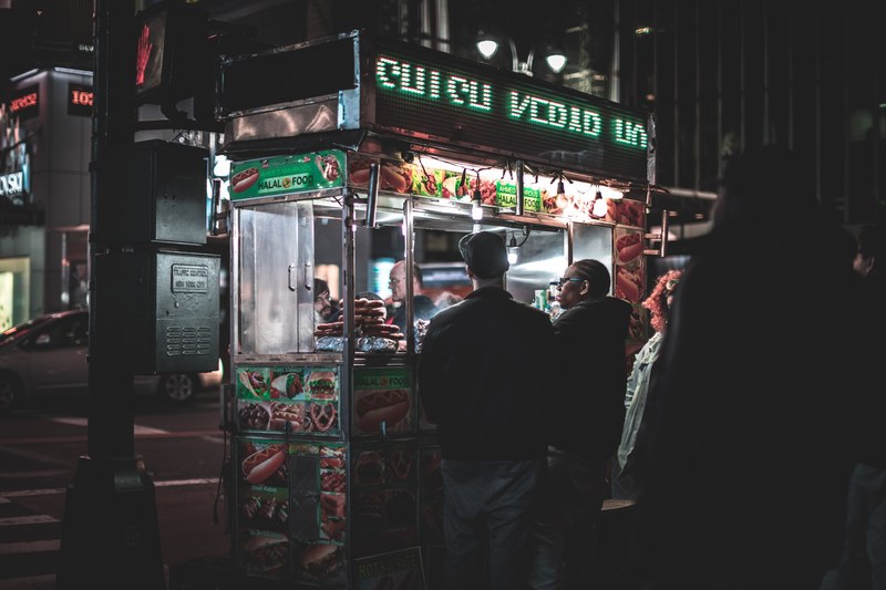 people lining up in front of a food cart serving fast food at night, the food of the city_ 4k