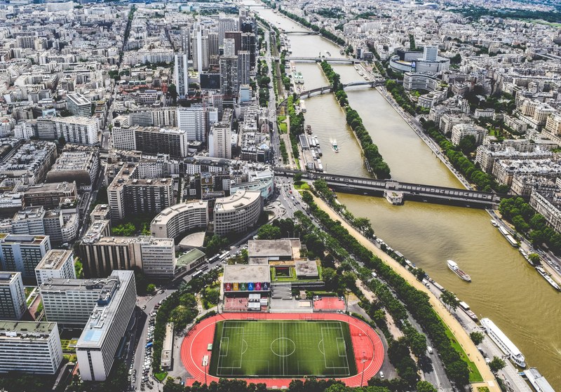drone shot of paris showing skyscrapers a soccer and track field and boats on river seine, drone shot paris city 4k