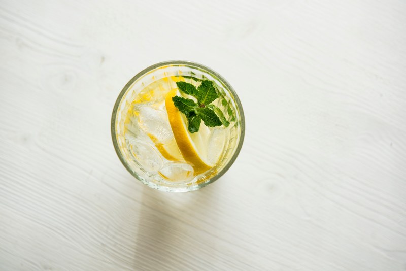 the top view of a glass of water with a slice of lemon and ice inside it, top view of a glass of water 4k