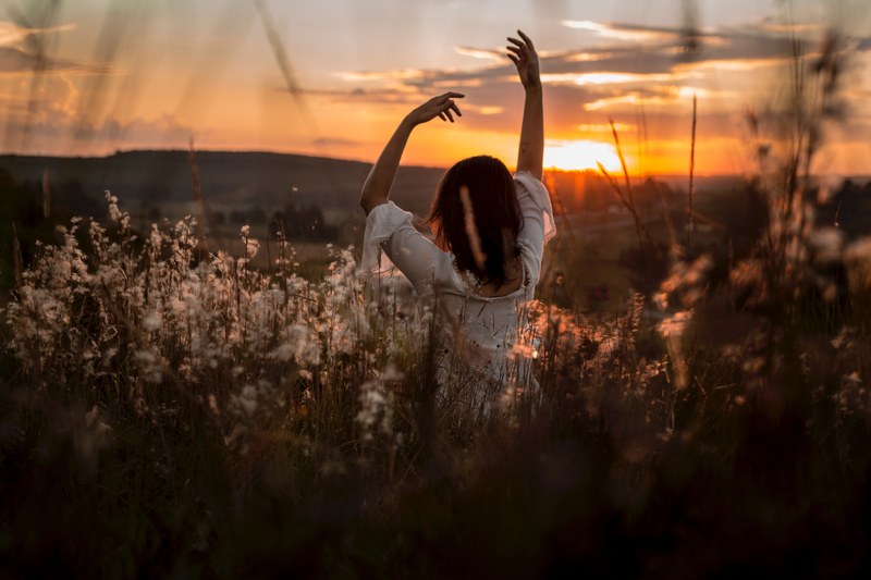 brunette woman doing a yoga pose inside long grass in curitiba at sunrise, woman yoga pose sunrise 4k