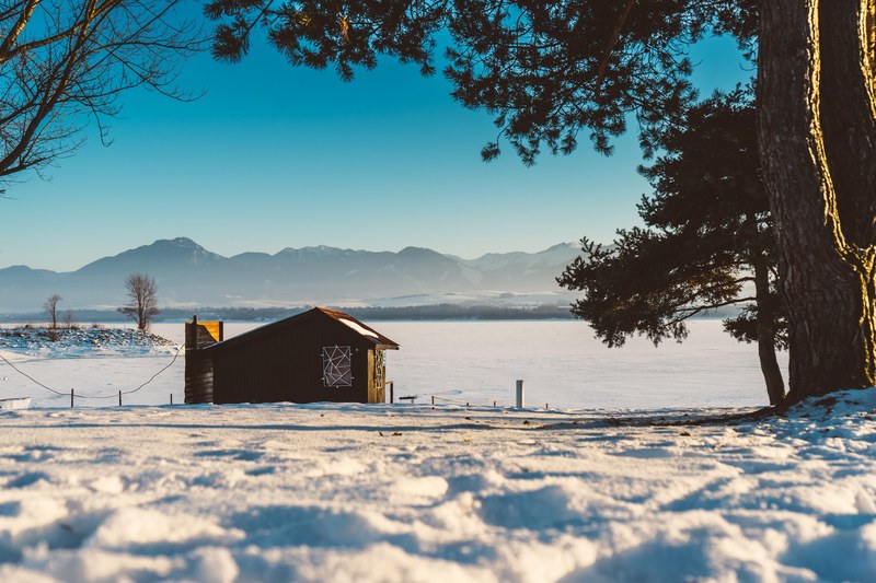 a winter shot of a shack at the bottom of mountains in liptovsk trnovec slovakia, cabin near liptovska mara slovkia 4k