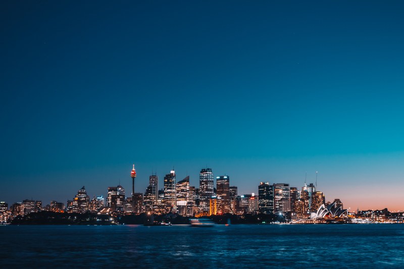 illuminated buildings and skyscrapers in the distance illuminated at sunset in cremorne reserve, coastal illuminations at sunset 4k