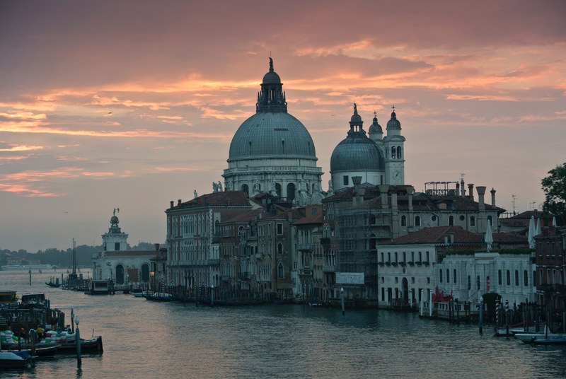 light orange and pink sunset reflected in the water in venice with clear cityscape and architecture in detail, venice cityscape sunset_ 4k