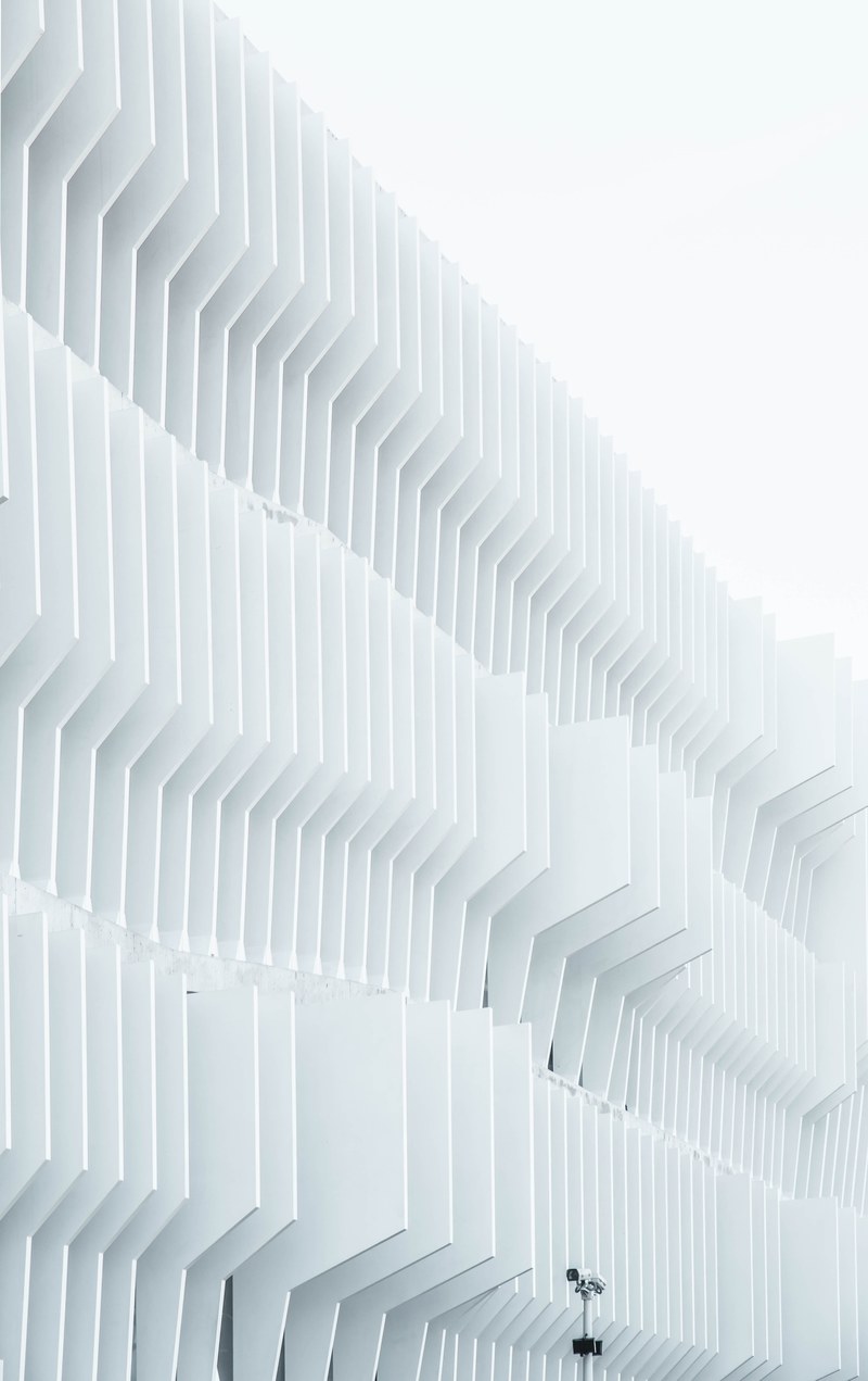 a security camera near parallel white ribs in a building facade in madrid, security camera near a facade 4k