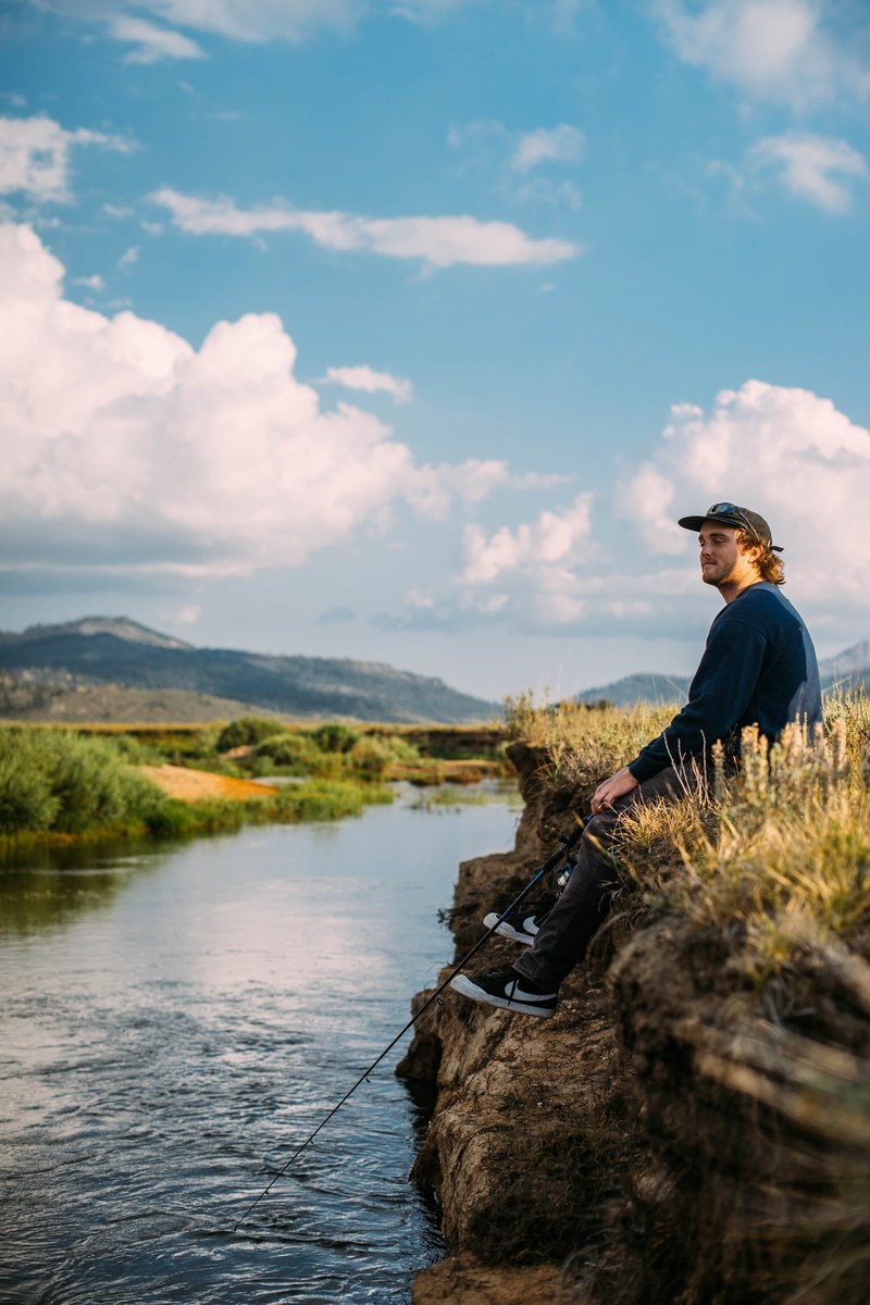 man fishing alone with pole on a river bank, fishing alone 4k