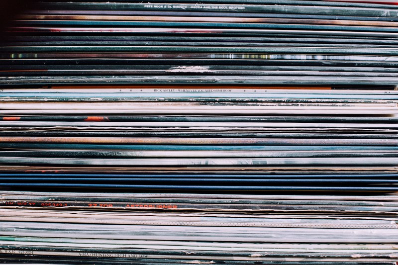 a background consisting of a stack of records in the city of nancy france, nancy record label shop items 4k