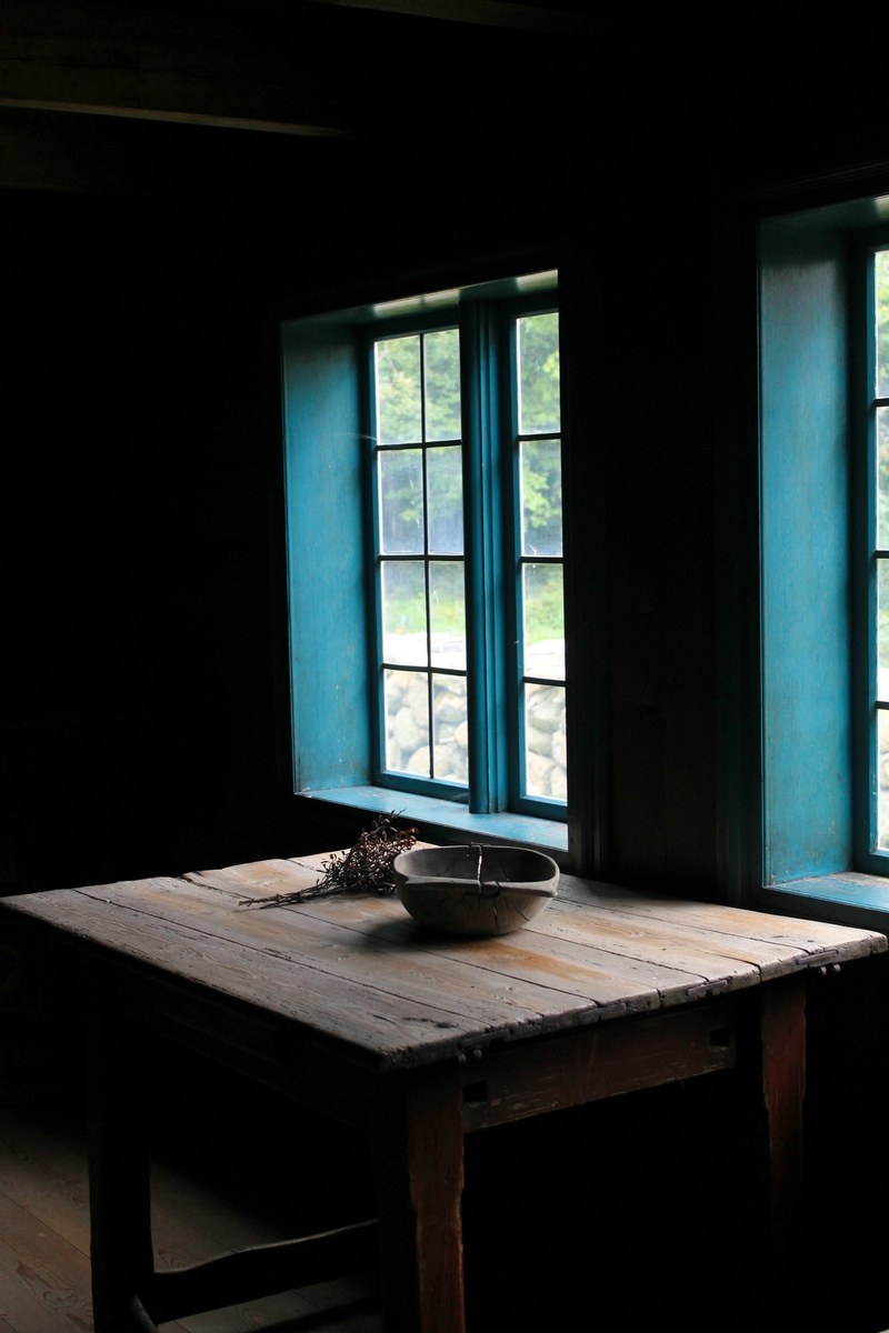 a wooden table with a bowl on it near a window in folkemuseet, folkemuseet window table 4k