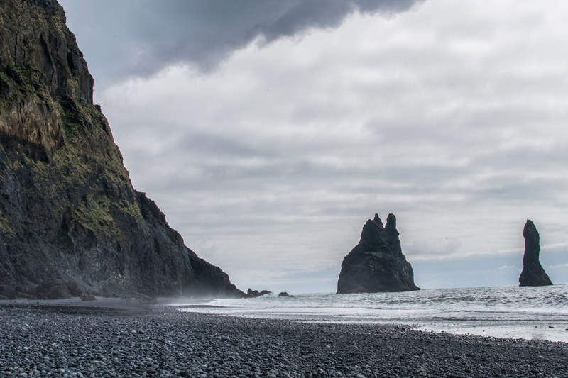 rock formations by the tall cliff at the iceland black sand coastline, rocky coastline at iceland 4k