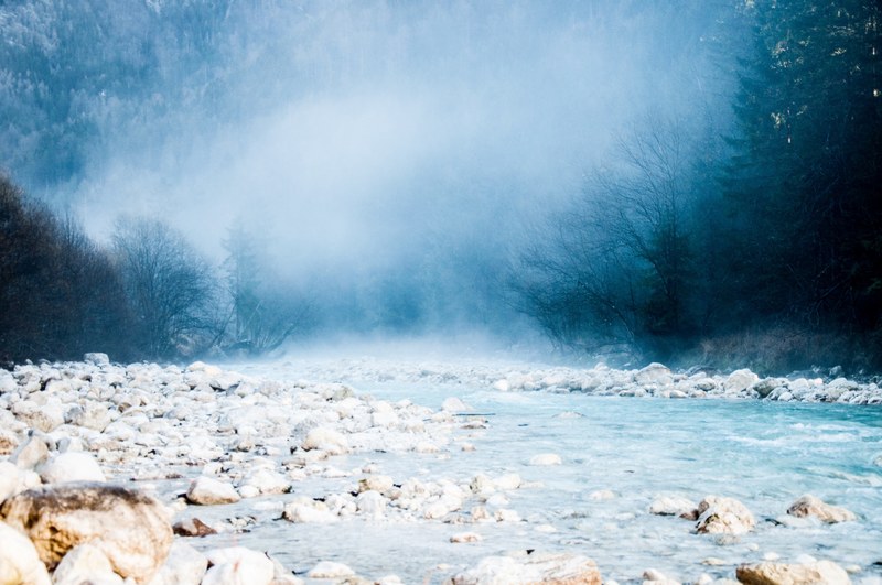 a thick cloud rolling over a rocky stream in the forest, a cloud covered stream 4k