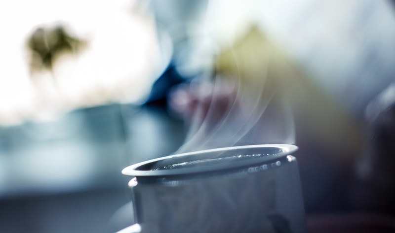 top of a mug steaming with a blurred outdoorsy background, steaming coffee mug 4k