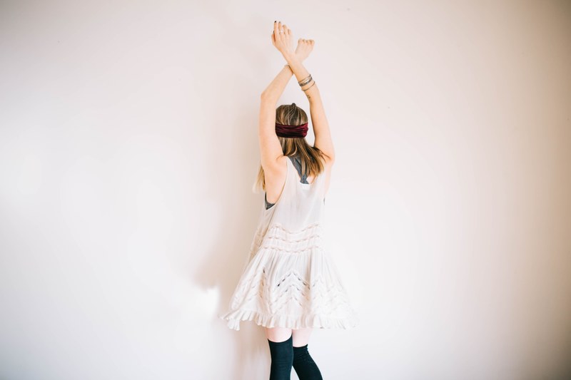 a woman in a white dress and black knee socks dancing near a wall, woman in a dress dancing alone 4k