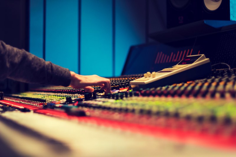 a close up of the hand of a sound engineer making adjustments on the soundboard, _sound engineer hand soundboard 4k