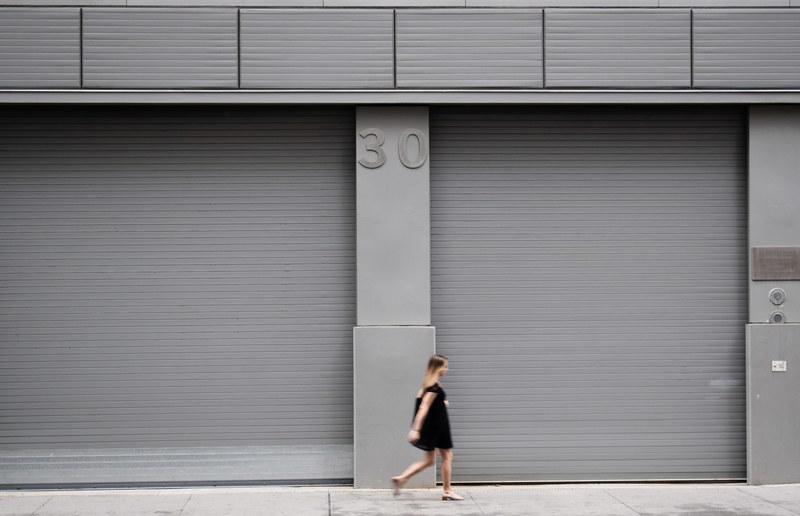 a woman walks along a gray colored building with the number 30, _woman gray building 30 4k