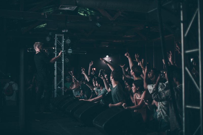 a man playing the trumpet in front of an enthusiastic young audience in austin, trombone 4k