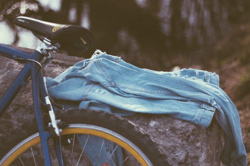 a pair of blue denim jeans on a log next to a bike in prejmer, get l o s t ii 4k