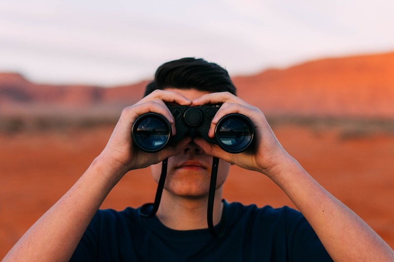 a man looking through binoculars in the desert, desert explorer 4k