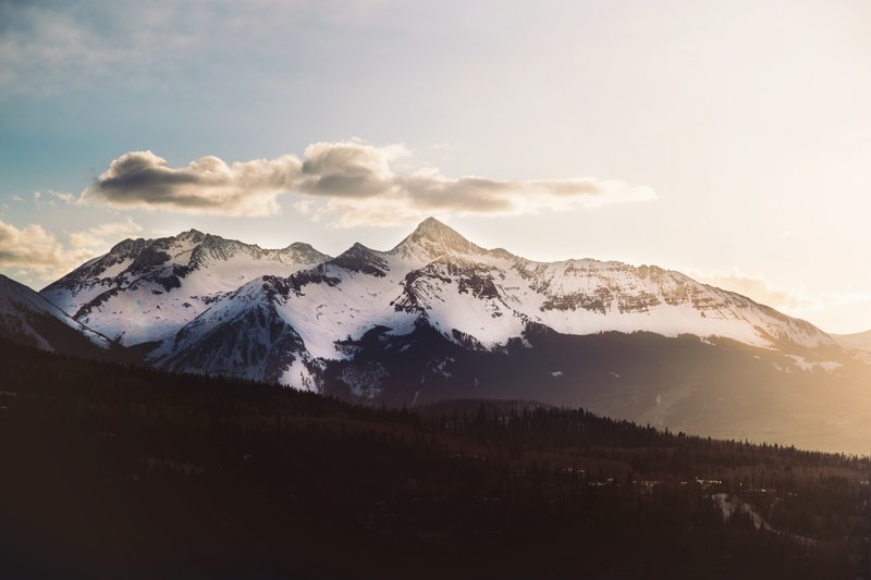 a tall snow capped mountain under thin clouds in telluride, clouds over a mountain in telluride 4k