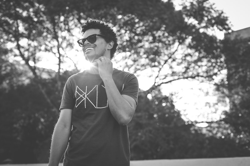 black and white shot of young man in sunglasses smiling with sun and tree brasilia, young man smile in brasilia 4k