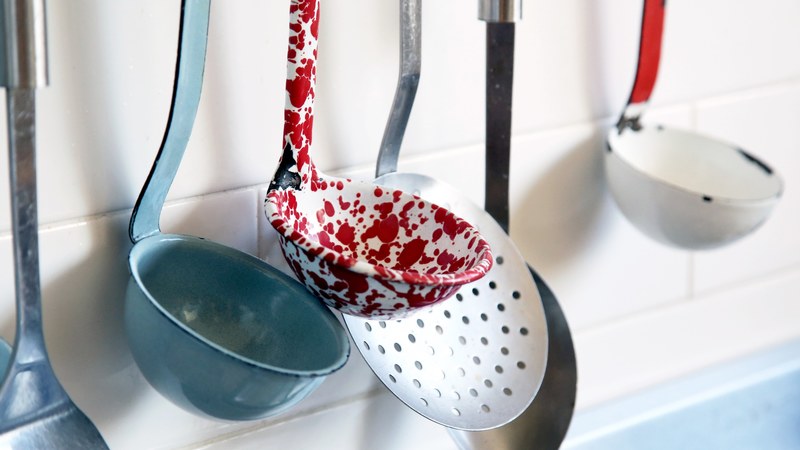 decorative kitchen ladles hang against tile, kitchen utensils on display 4k